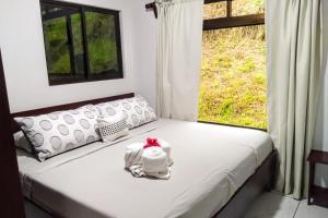 una camera con un letto bianco e una finestra di Amazing Villa at Lake Arenal 2 a Tronadora
