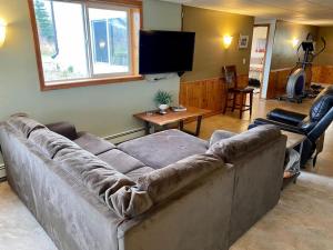 ein Wohnzimmer mit Couch und Fernseher in der Unterkunft Northern Lights from Hot Tub, Denali National Park in Healy