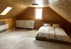 a attic bedroom with a bed and a window at Domček pod Orechom in Blatnica