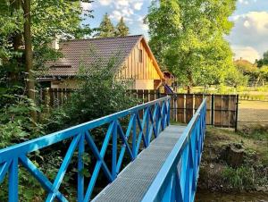 a blue bridge in front of a wooden house at Domček pod Orechom in Blatnica