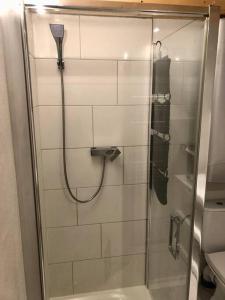 a shower with a glass door in a bathroom at Domček pod Orechom in Blatnica