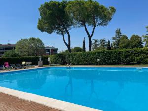 une grande piscine bleue avec des arbres en arrière-plan dans l'établissement fior di loto, à Desenzano del Garda