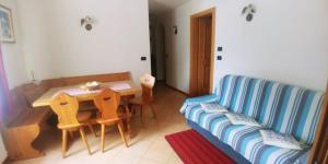 a living room with a table and a blue couch at Plodar èscht in Sappada