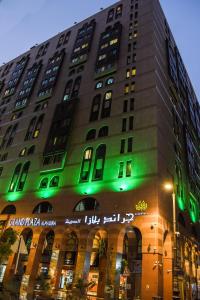 ein hohes Gebäude mit grüner Beleuchtung in der Unterkunft Grand Plaza Al Madina in Medina