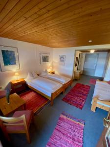 een slaapkamer met 2 bedden en 2 tafels en tapijten bij Pension am See in Wörthsee