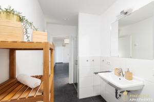 a white bathroom with a sink and a toilet at Pineapple Apartments Dresden Zwinger VII - 78 qm - 1x free parking - in Dresden
