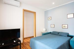 a bedroom with a blue bed and a flat screen tv at Lisboa Sweet Family Homestay in Lisbon