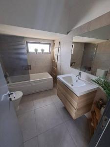 a bathroom with a tub and a sink and a toilet at Villa Ocean Waves in Aroeira +39 photos