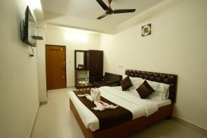 ein Schlafzimmer mit einem Bett mit zwei ausgestopften Tieren darauf in der Unterkunft Ganesh Guest House in Chennai
