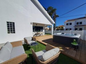 a patio with a hot tub in a yard at Villa Ocean Waves in Aroeira