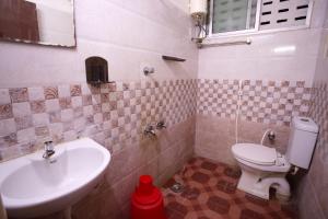 La salle de bains est pourvue d'un lavabo et de toilettes. dans l'établissement Ganesh Guest House, à Chennai