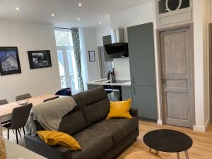 ein Wohnzimmer mit einem Sofa und einer Küche in der Unterkunft Les balcons du Sancy - Appartement neuf 3 étoiles in Le Mont-Dore