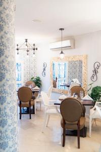 una sala da pranzo con tavoli e sedie e una stanza con finestre di Hotel Boutique ADAZ a Santa Marta