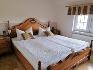 a bedroom with a large wooden bed with pillows at Landtraum im Traumland Mecklenburg in Warin