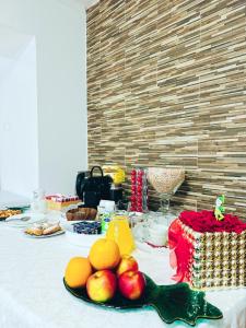 a table with apples and oranges and a cake at Pensiunea Zimbrul in Poiana Brasov