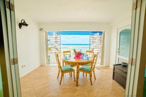 Gorgeous Ocean Views! Welcome to Bella Breeze! BeachFront 2BR 2BA في Sion Farm: غرفة طعام مع طاولة وكراسي أمام النافذة