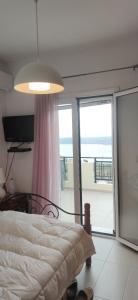 a bedroom with a bed with a view of the ocean at Όμορφο διαμέρισμα με θέα in Korakiaí