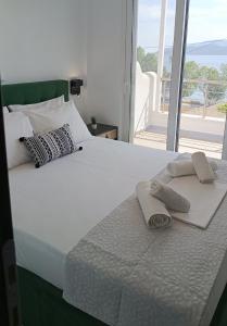 uma cama branca com duas toalhas em cima em Enigma Boutique Houses Vraxos em Marmari