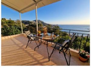a table and chairs on a balcony with the ocean at Myrties House in Kalymnos
