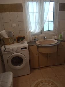 y baño con lavadora y lavamanos. en Myrties House en Kalymnos