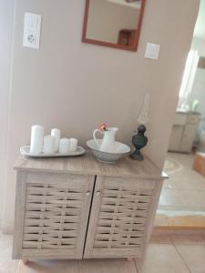 a wooden cabinet with cups and plates on top of it at Myrties House in Kalymnos