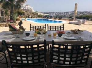 a table with food and drinks on top of a patio at Navy Blue Suites in Ornos