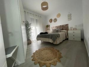 Apartamento Victoria A في Fuente Obejuna: غرفة نوم مع سرير وسجادة على الأرض