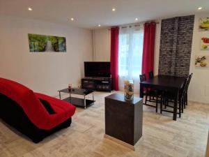 a living room with a red couch and a table at Superbe appartement 2 pièces - Aix-les-Bains Riviera des Alpes - Parking gratuit in Aix-les-Bains