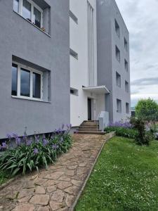 a building with purple flowers next to a walkway at Superbe appartement 2 pièces - Aix-les-Bains Riviera des Alpes - Parking gratuit in Aix-les-Bains