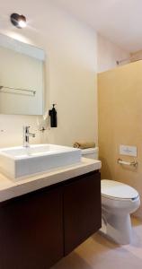 W łazience znajduje się umywalka, toaleta i lustro. w obiekcie Casa Arrayan Telchac w mieście Telchac Puerto