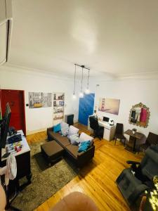 ein Wohnzimmer mit einem Sofa und einem Schreibtisch in der Unterkunft Rostelbem Guesthouse Lisbon in Lissabon