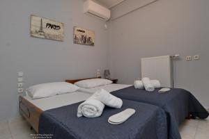 two beds with towels on them in a bedroom at Eleni's Pool Villa in Káto Soúlion