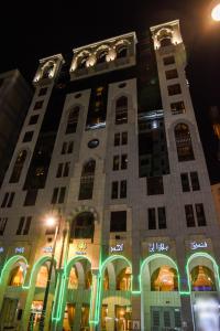 un edificio alto con luces verdes. en Plaza Inn Ohud Hotel, en Medina