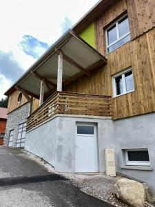 a house with a deck on the side of it at Les gîtes de la bergerie in Xonrupt-Longemer