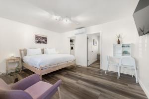 a bedroom with a bed and two chairs and a table at The Franciscan Hotel in Santa Barbara +23 photos