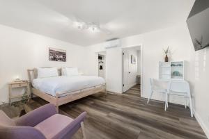 a bedroom with a bed and two chairs and a table at The Franciscan Hotel in Santa Barbara