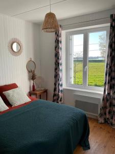 - une chambre avec un lit bleu et une fenêtre dans l'établissement Havre de paix à Carteret !, à Barneville-Carteret