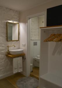 a bathroom with a sink and a toilet at Casa do Theatro Guest House in Barcelos