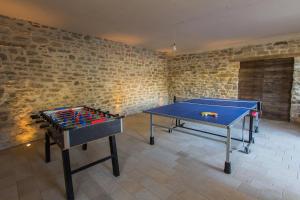 duas mesas de pingue-pongue numa sala com paredes de tijolos em Appartamenti Gli Ippocastani em San Benedetto Belbo