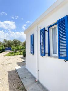 a white building with blue shutters on it at Tea House Alghero in Alghero +17 photos