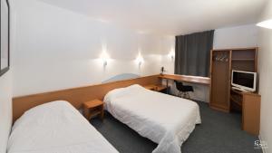 a hotel room with two beds and a television at Hotel First Rodez in Rodez