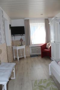 ein Wohnzimmer mit einem TV und einer roten Couch in der Unterkunft Pension Fernblick in Bad Karlshafen