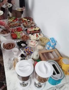 ein Tisch mit einem Buffet mit Speisen drauf in der Unterkunft Casa Munty in Orlat