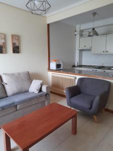 een woonkamer met een bank en een salontafel bij Apartamento primera línea playa d samil in Vigo