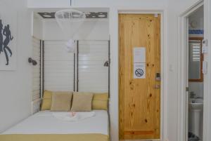 Habitación con cama blanca y puerta de madera. en Begona Cliff Hotel, en Negril