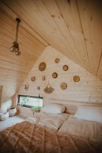 sypialnia z dużym łóżkiem w drewnianym suficie w obiekcie Domki Przystań Spławy 