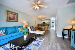 a living room with a blue couch and a table at Lovely Townhouse One Block to the Beach in Myrtle Beach