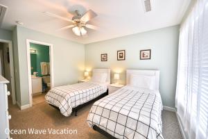 a bedroom with two beds and a ceiling fan at Lovely Townhouse One Block to the Beach in Myrtle Beach