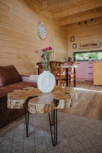 sala de estar con sofá y mesa con troncos en Domki Przystań Spławy, 