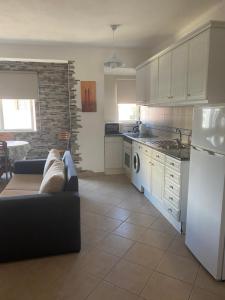 a kitchen with a couch and a white refrigerator at Castelos da Rocha in Portimão